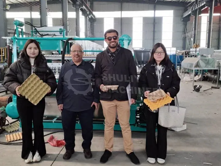 Los clientes visitan la fábrica de fabricación de cartones de huevos